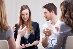 Young woman talking about her life on group therapy